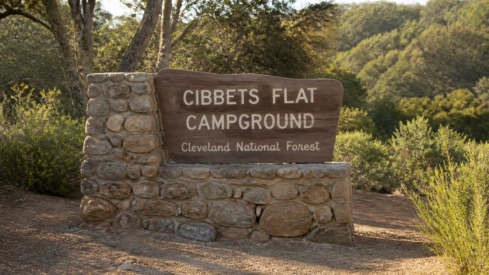 Wooden Cibbets Flat Campground sign on a stone pillar among oaks in Cleveland National Forest